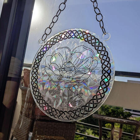 An acrylic suncatcher with a flower.